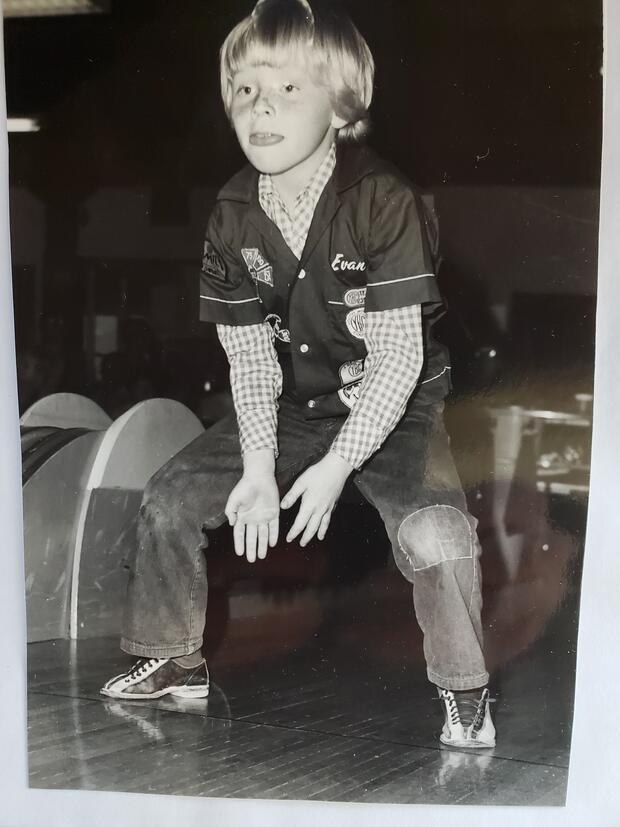 Youth bowler after delivering ball down alley